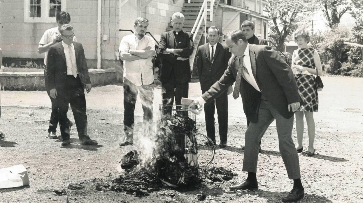 Tom Melville puts more fuel on the burning draft cards at the Selective Service office in Catonsville on May 17, 1968