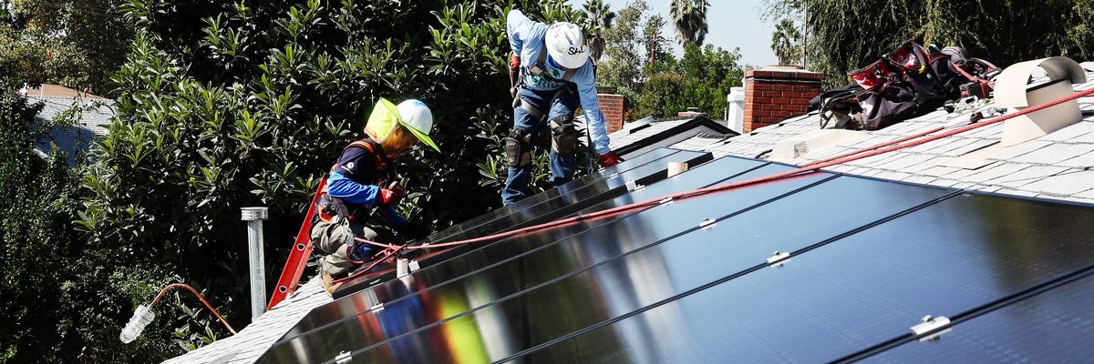 Tony Chang (L) and Sal Miranda install no-cost solar panels