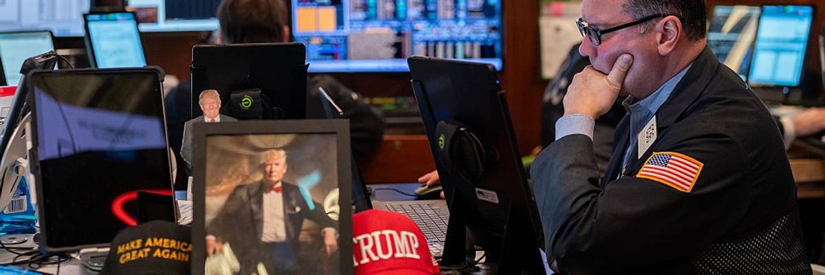 Traders work on the floor of the New York Stock Exchange, next to memorabilia for President Donald Trump