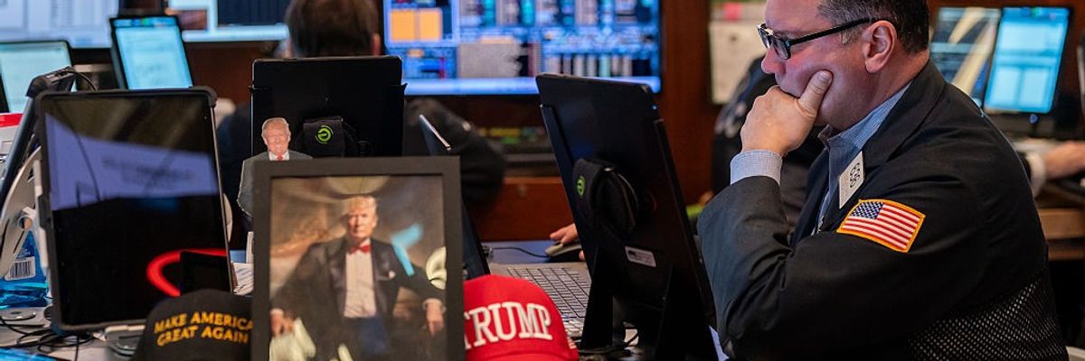 Traders work on the floor of the New York Stock Exchange, next to memorabilia for President Donald Trump