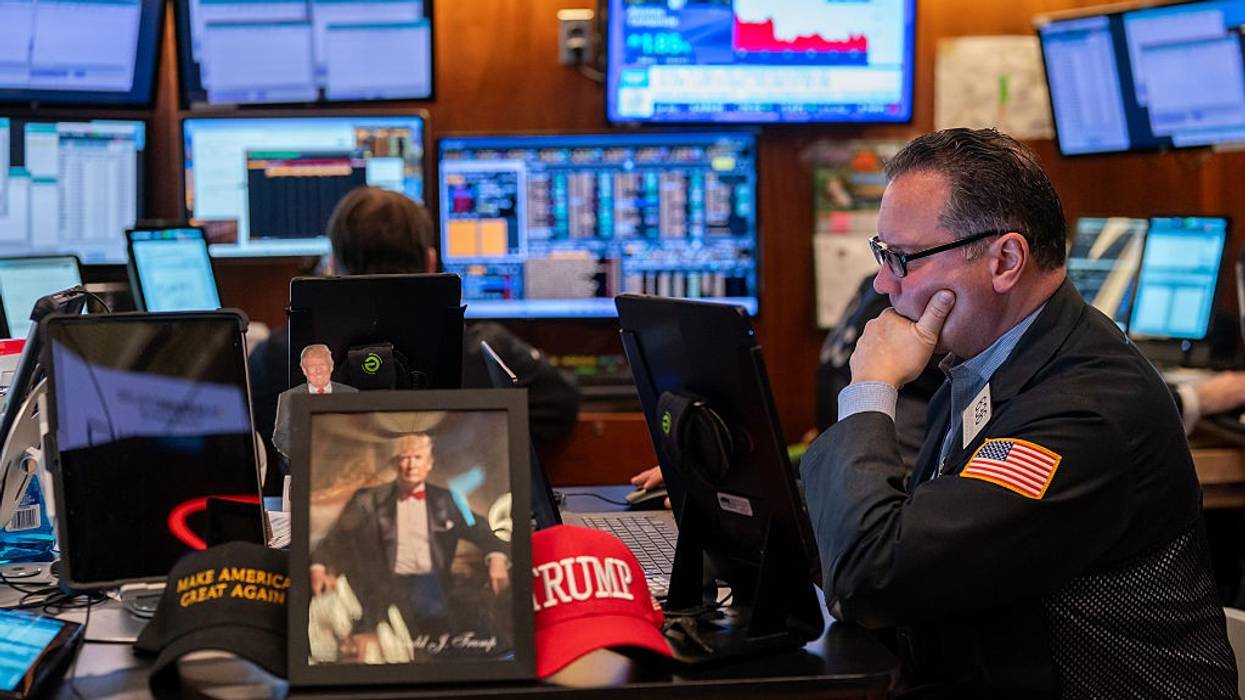 Traders work on the floor of the New York Stock Exchange, next to memorabilia for President Donald Trump
