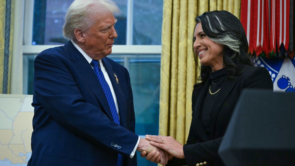 Trump and Gabbard shake hands.