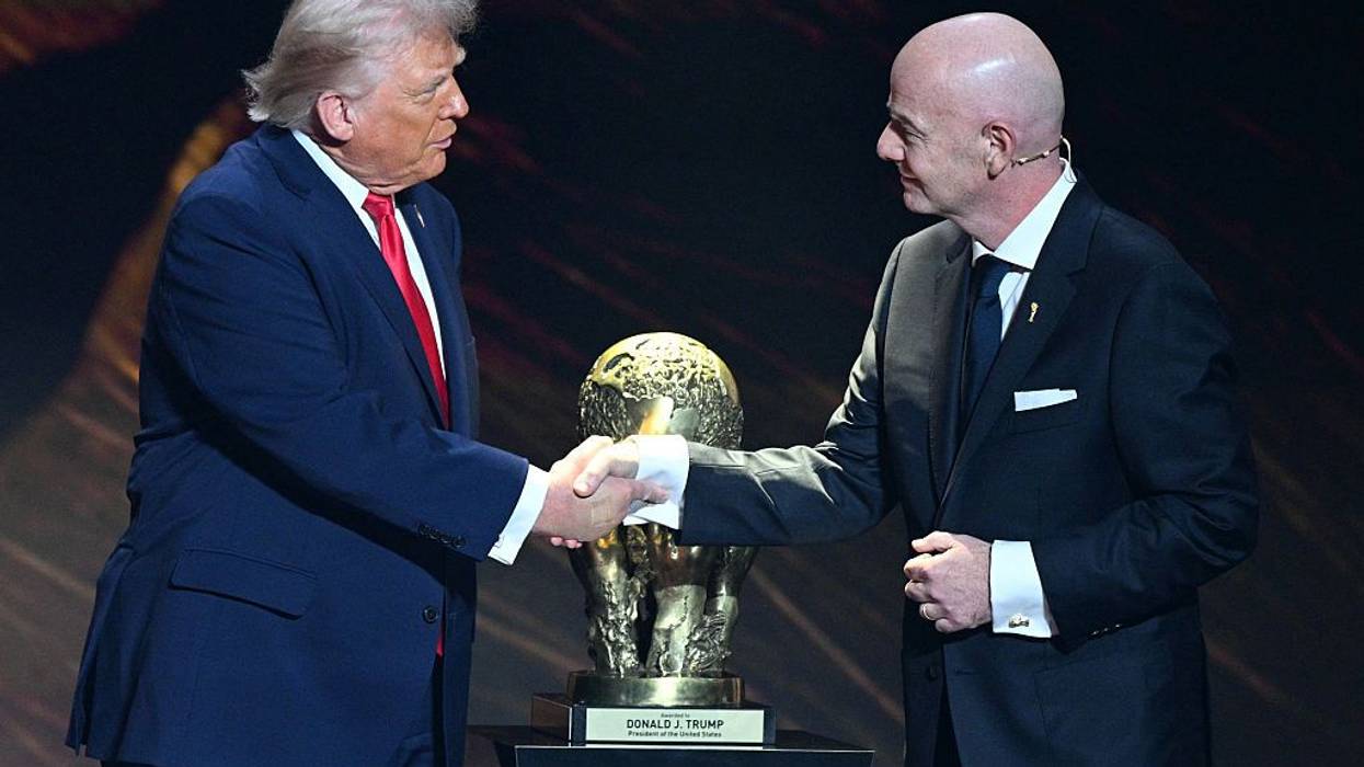 Trump and Infantino of FIFA shake hands in front of FIFA Peace Prize.