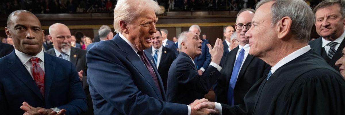 Trump and John Roberts shake hands.