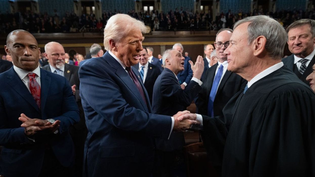 Trump and John Roberts shake hands.