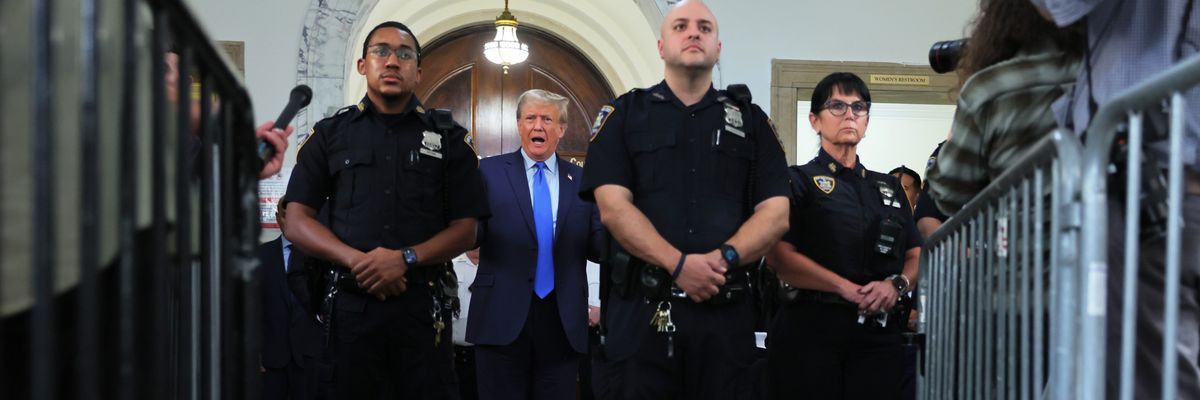Trump at his fraud trial in New York with New York policemen around him.