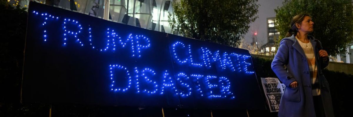 "Trump Climate Disaster" sign outside US Embassy