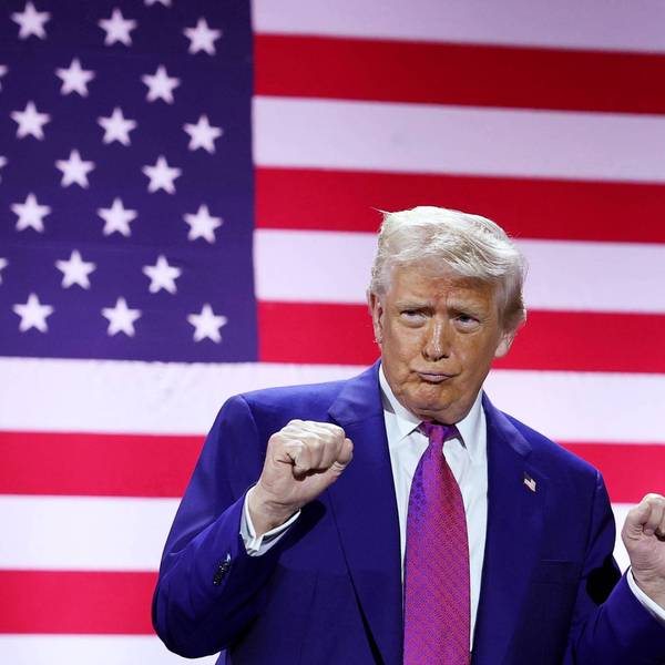 Trump dances in front of a giant US flag screen