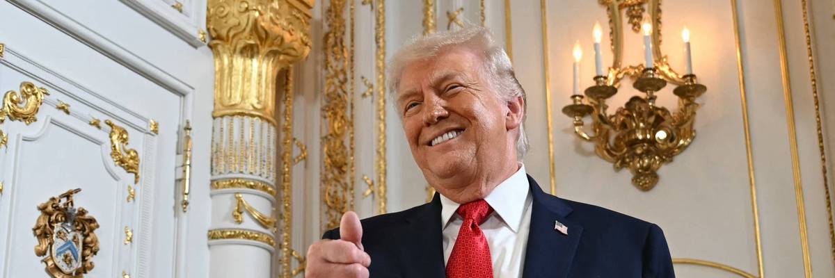 Trump gives a thumbs up with gold behind him.