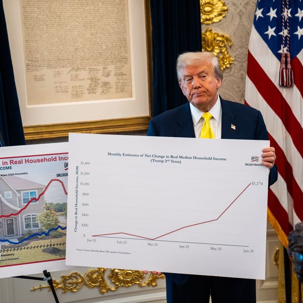 Trump holds a chart with economic data