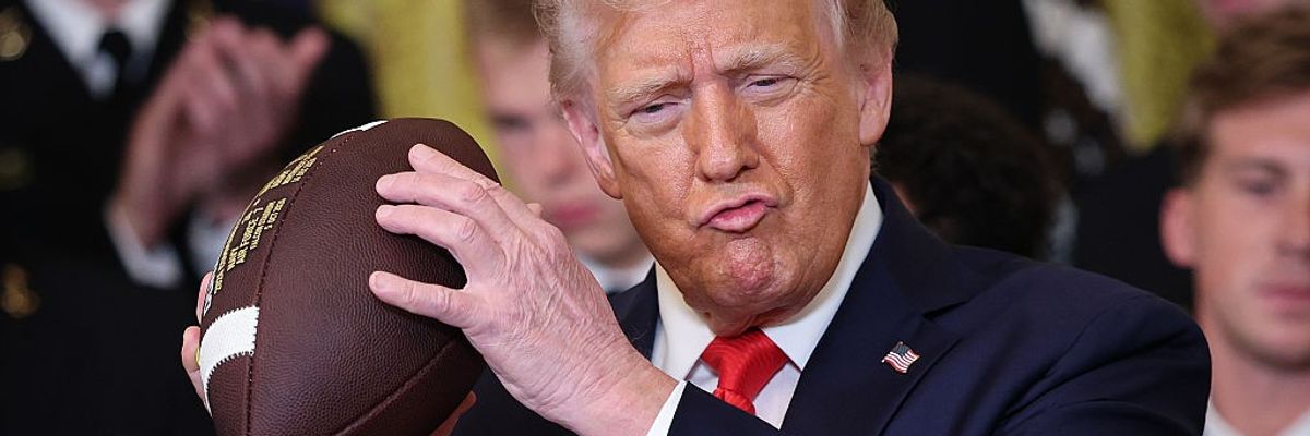 Trump holds an American football.