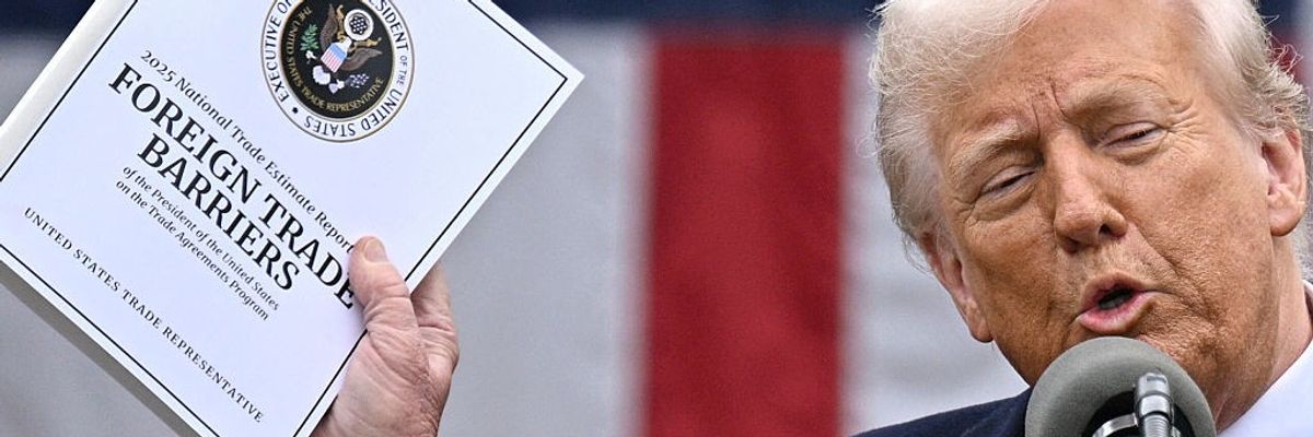 Trump holds up a documented related to tariffs.