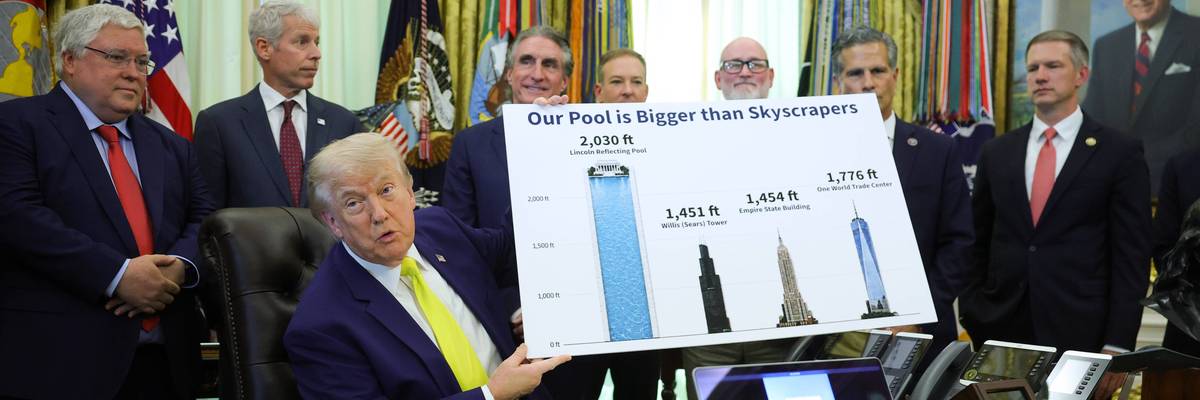 Trump holds up a poster reading, "Our Pool is bigger than skyscrapers."