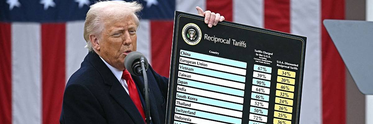 Trump holds up tariffs chart.
