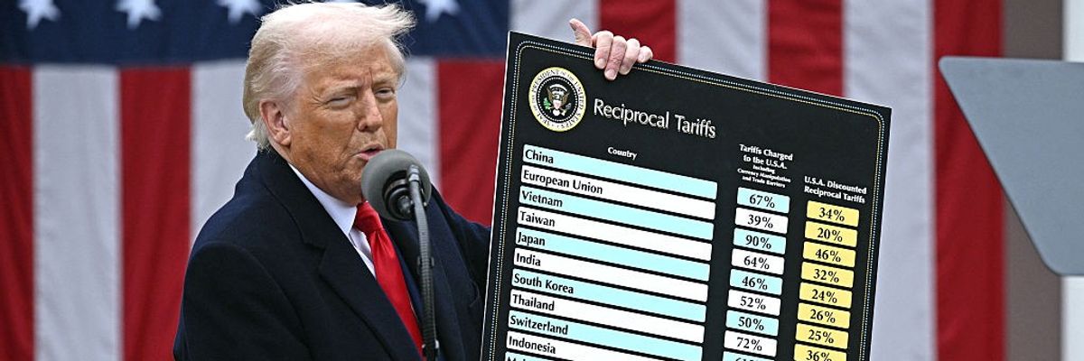 Trump holds up tariffs chart.