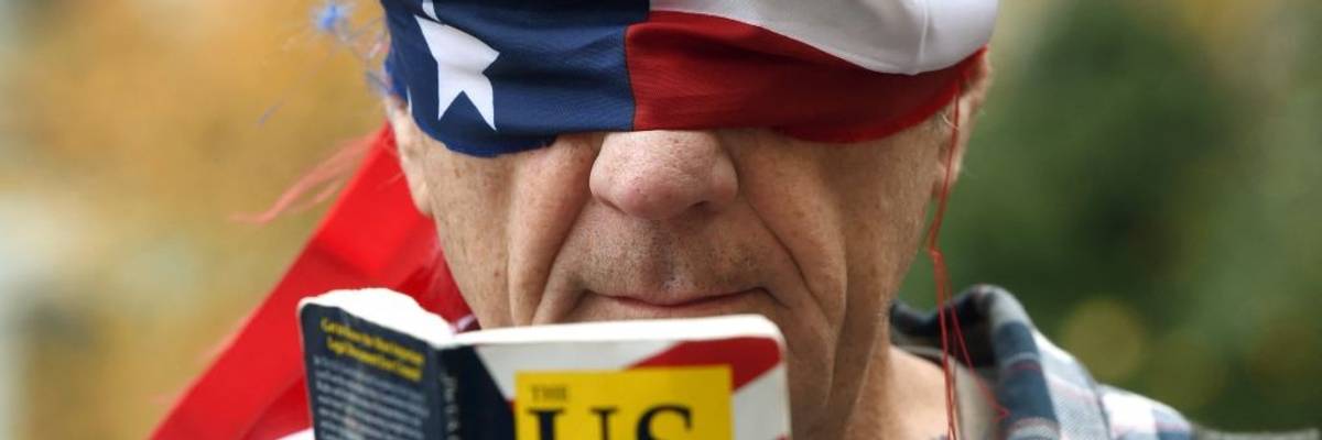 Trump protester reads Consitution blindfolded.