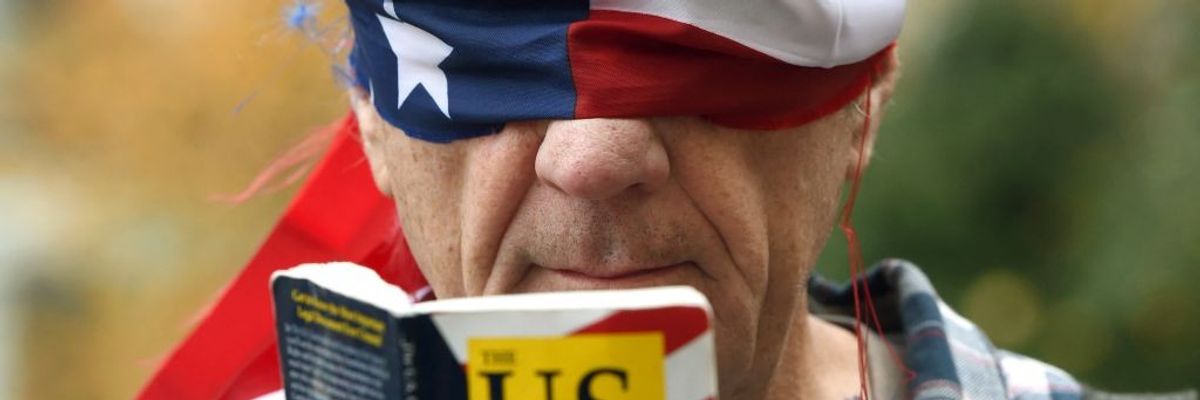 Trump protester reads Consitution blindfolded.