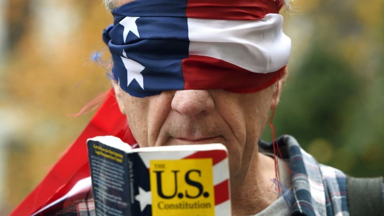 Trump protester reads Consitution blindfolded.