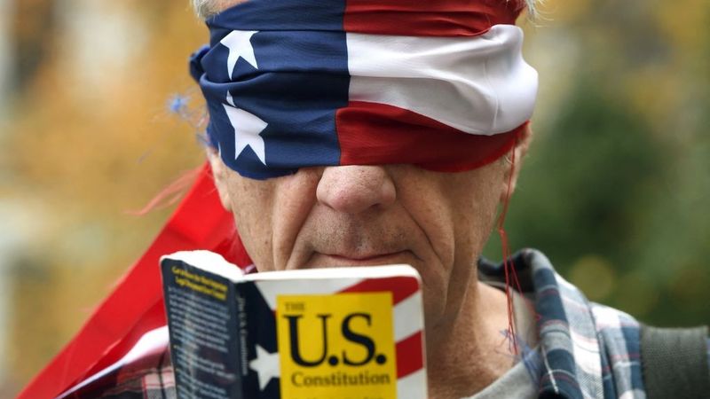 Trump protester reads Consitution blindfolded.