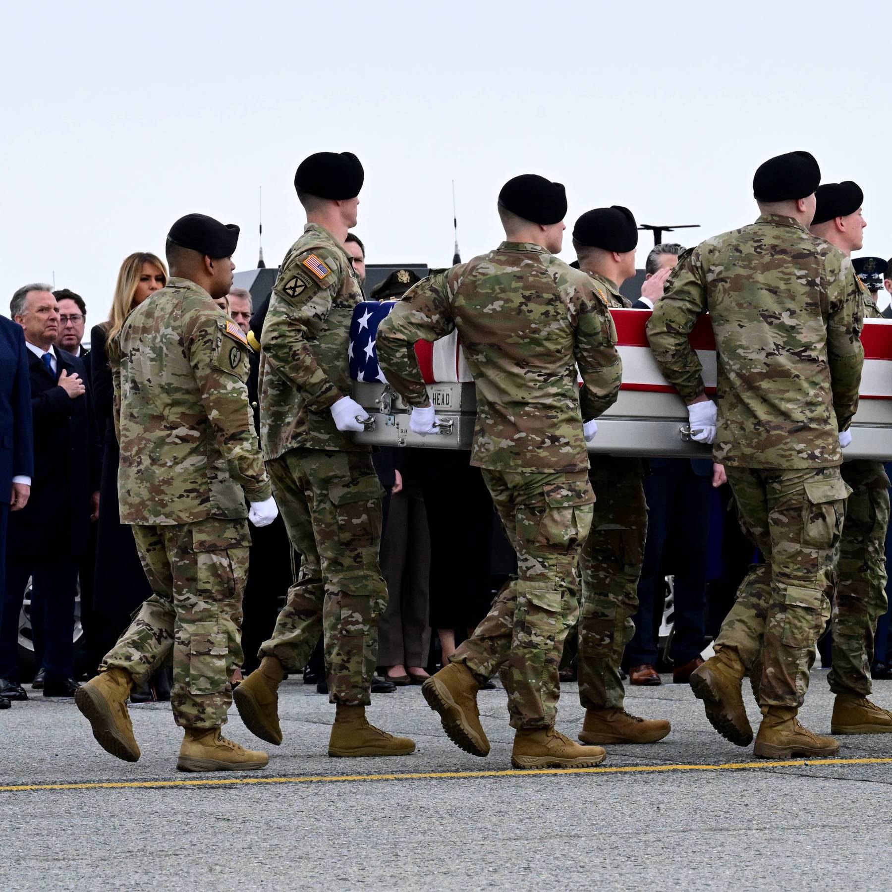 Trump salutes as soldiers carry a flag-draped casket