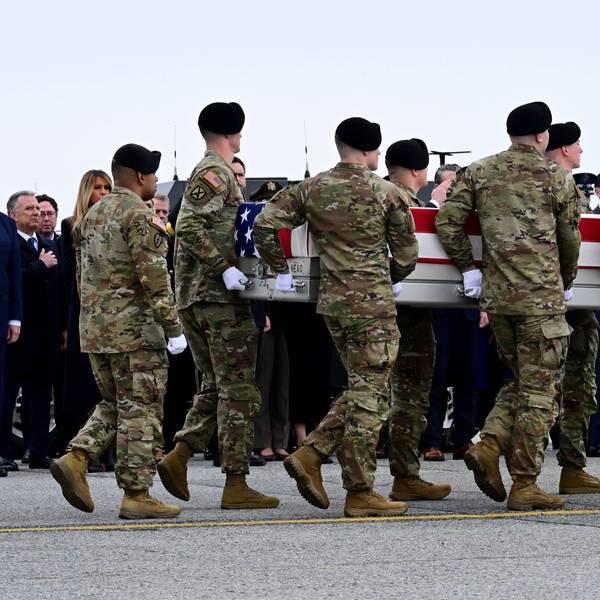Trump salutes as soldiers carry a flag-draped casket
