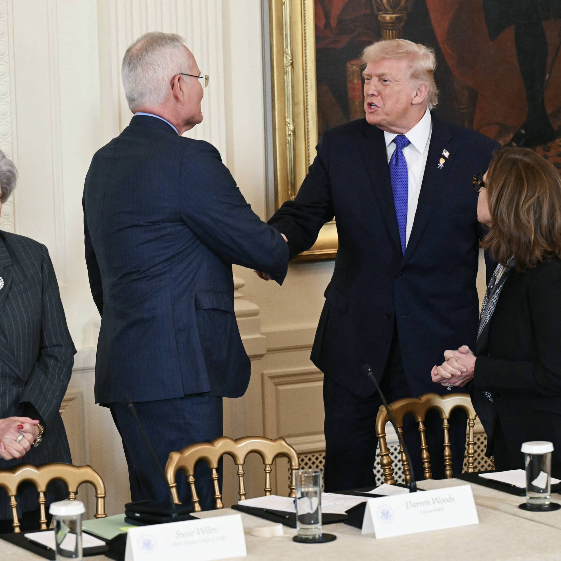 Trump shakes hands with Woods following Venezuelan invasion.