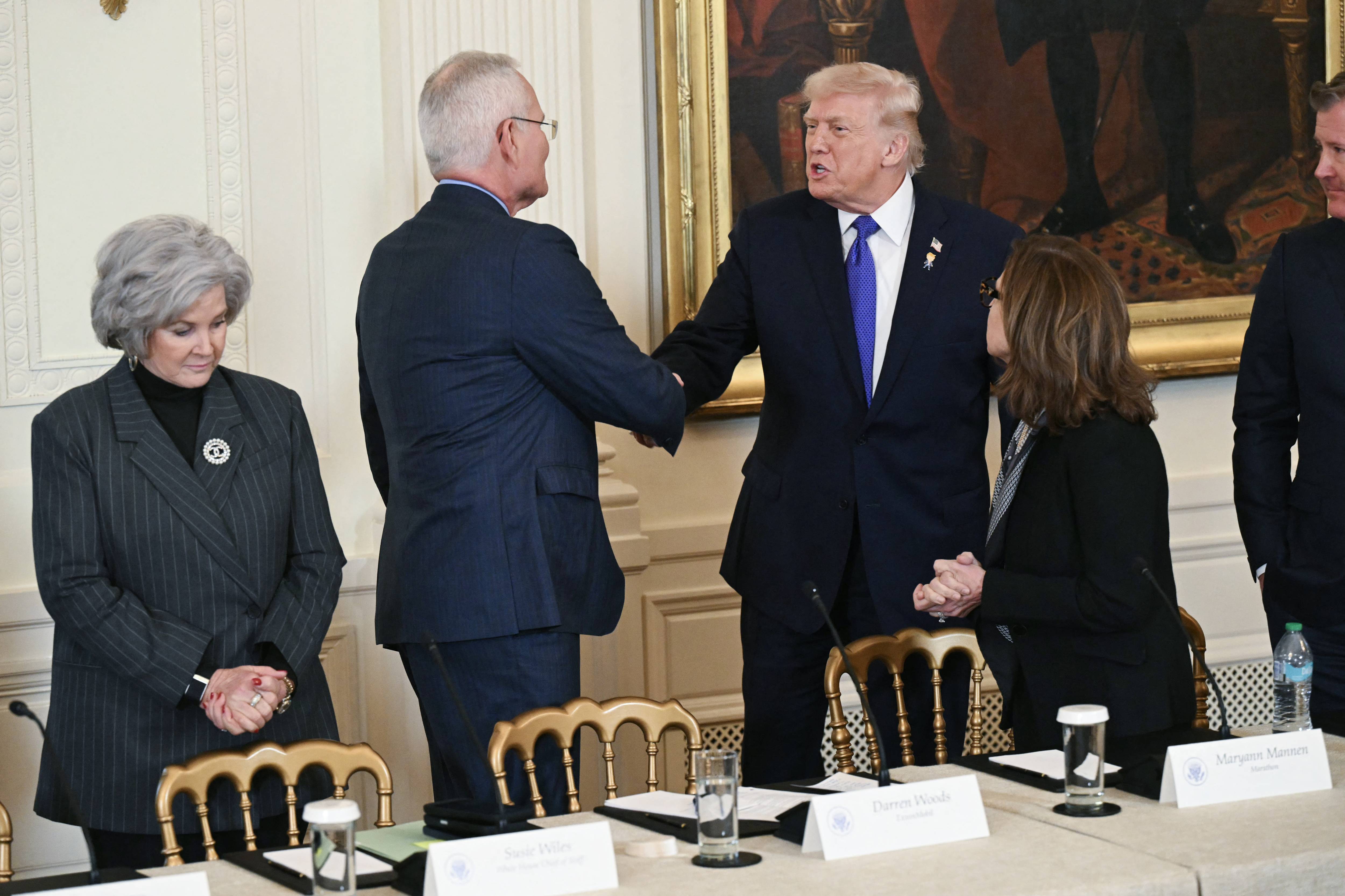 Trump shakes hands with Woods following Venezuelan invasion.