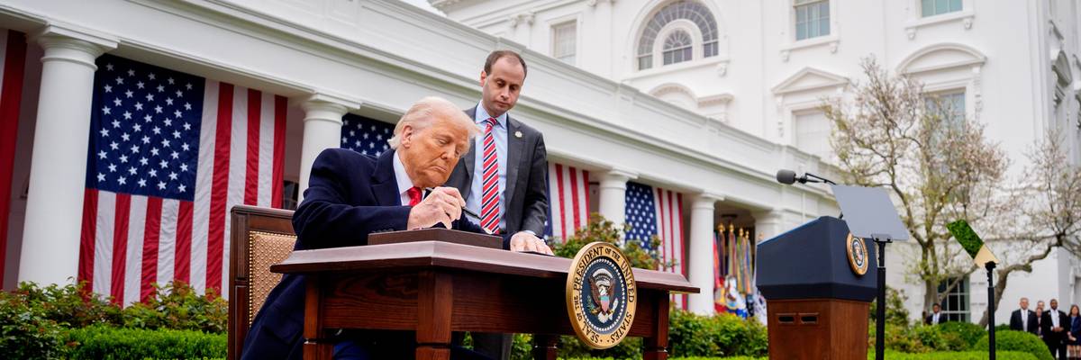Trump signs executive orders imposing tariffs outside White House.