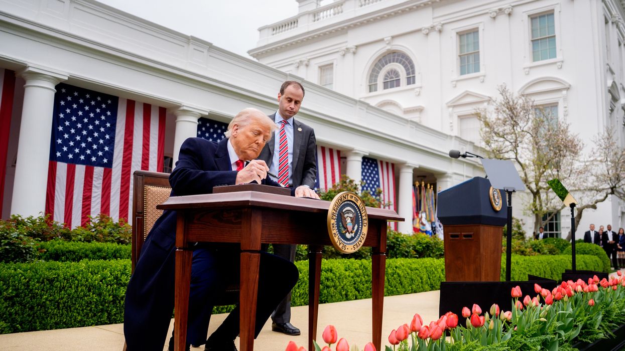 Trump signs executive orders imposing tariffs outside White House.