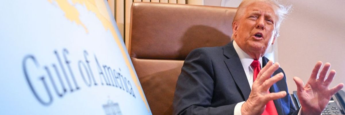 Trump sits next to a map showing the Gulf of America