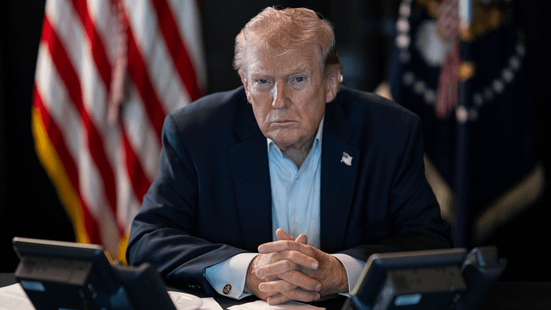 Trump sits with a stern look
