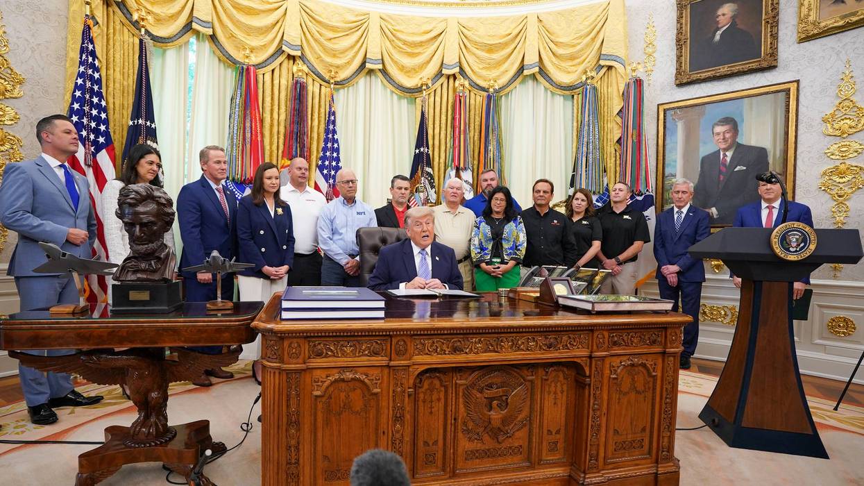 Trump speaks at the Oval Office surrounded by staff and supporters