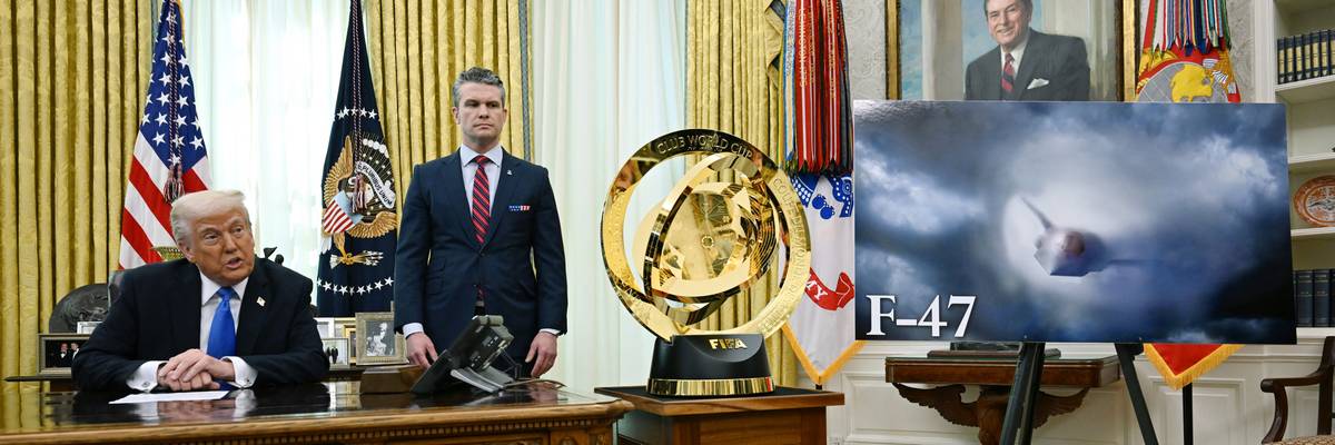Trump speaks from desk next to image of F-47 fighter plane.
