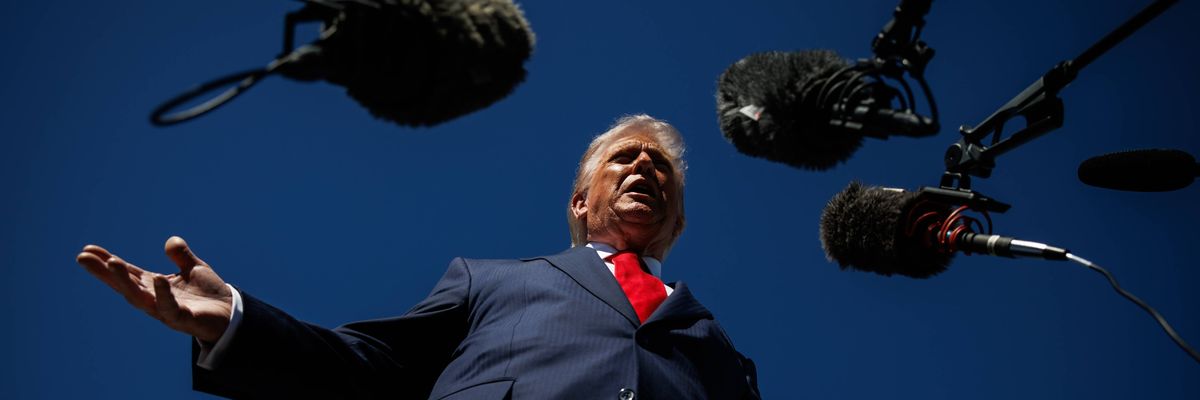 Trump speaks into microphones.