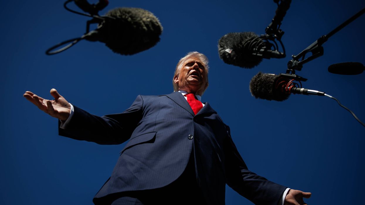 Trump speaks into microphones.