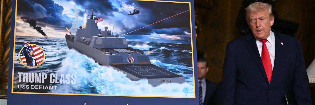 Trump stands next to an artist's rendering of the proposed Trump-class battleship