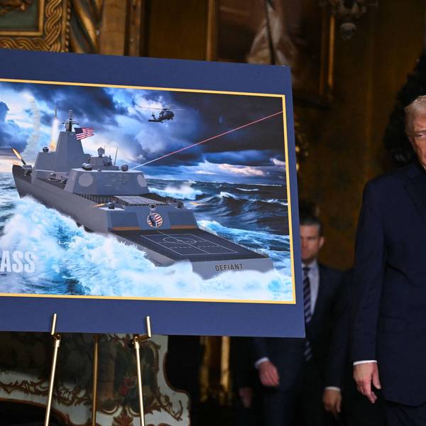 Trump stands next to an artist's rendering of the proposed Trump-class battleship