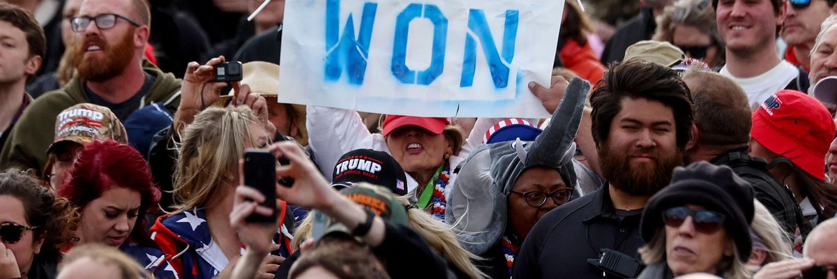 Trump supporters holding up 'Trump Won' sign at rally