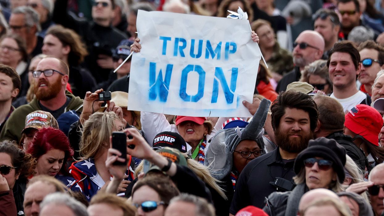 Trump supporters holding up 'Trump Won' sign at rally