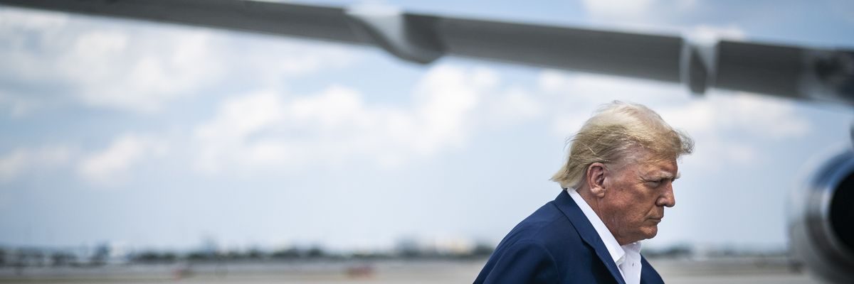 Trump with an airplane wing behind him.