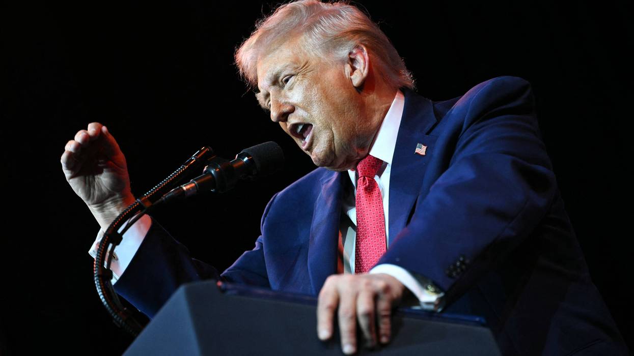 Trump yells into a microphone.