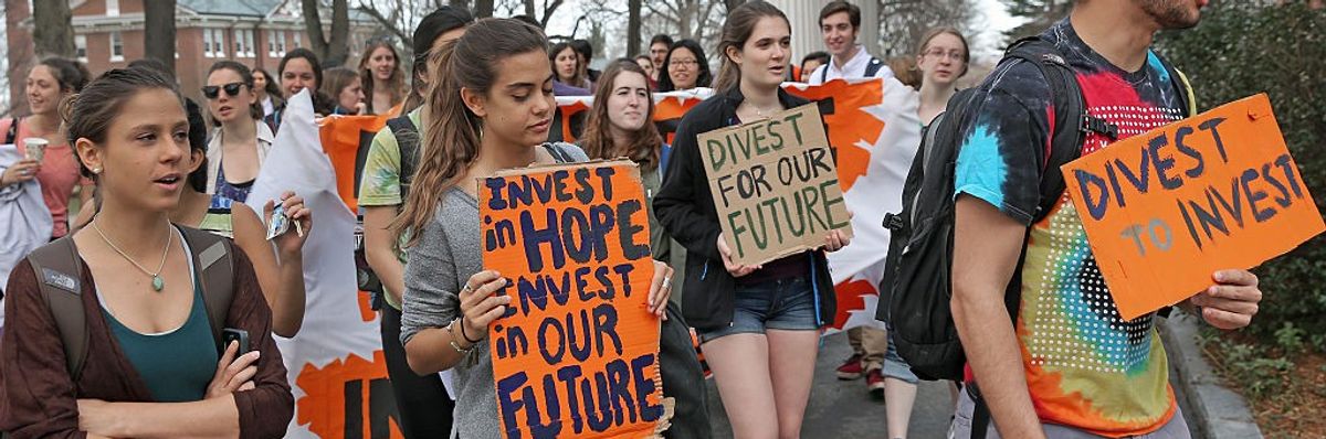 Tufts students carry signs demmanding fossil fuel divestment.