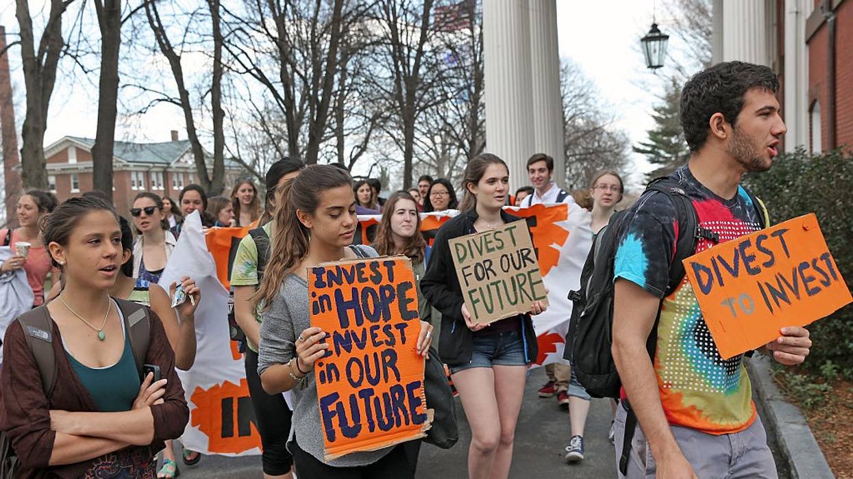 Tufts students carry signs demmanding fossil fuel divestment.