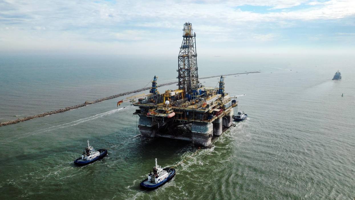 Tug boats tow a semi-submersible drilling platform in Port Aransas, Texas on December 12, 2020.