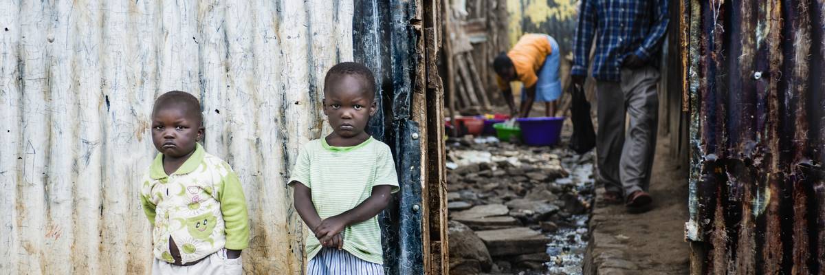 Two children stand outside their family home in Mathare, Kenya