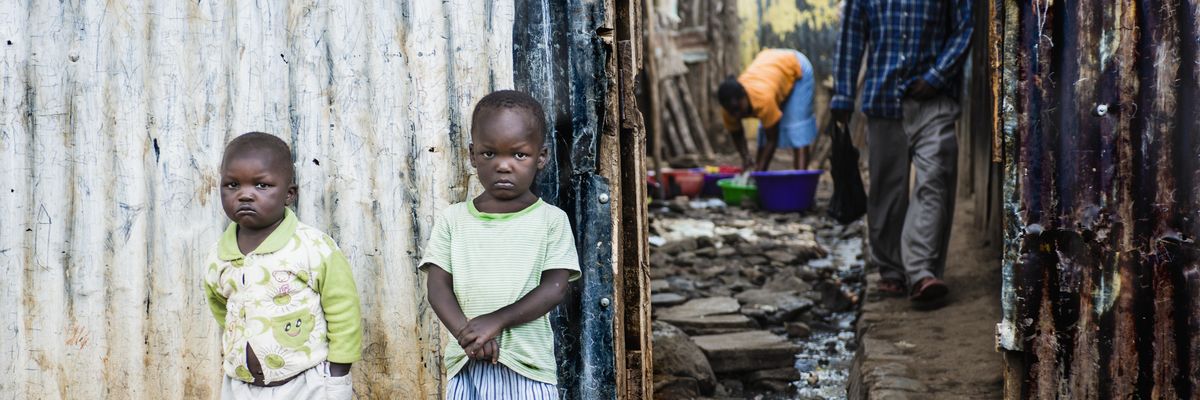 Two children stand outside their family home in Mathare, Kenya