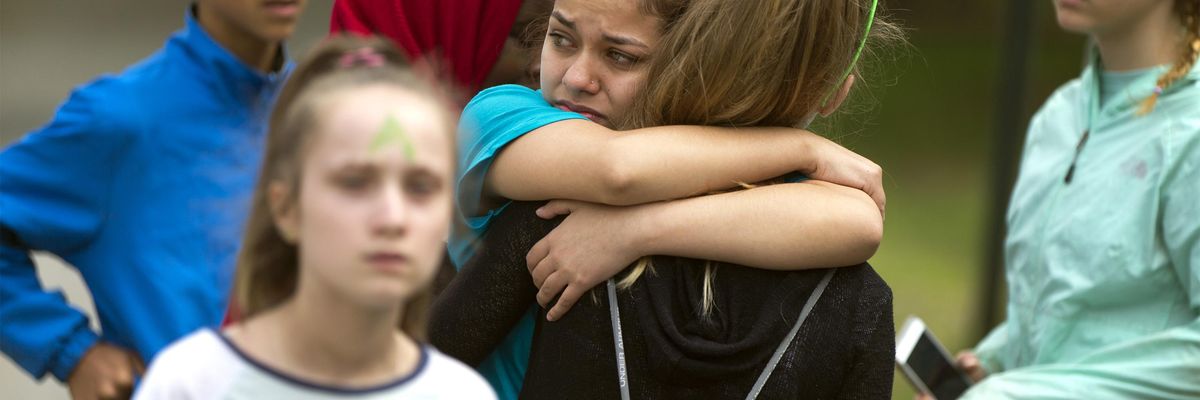 Two eighth grade students hug