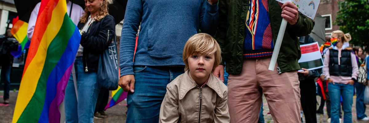 Two fathers with their child at a LGBTQ rights rally in Amsterdam