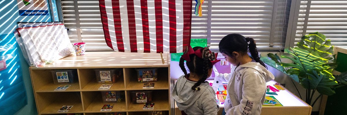 Two kindergarten students are seen in their classroom