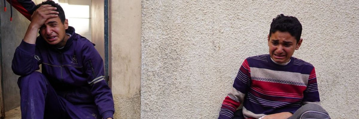 Two Palestinian boys cry over the dead bodies of loved ones in Gaza